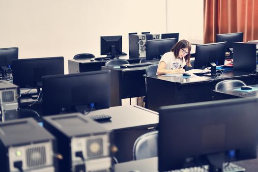 Only one female student in computers and  technology classroom working and learning concept of persistence