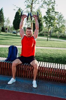 athletic man in red t-shirt in fitness park. High quality photo