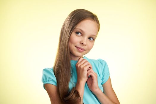 cheerful little girl with long hair close-up studio posing. High quality photo
