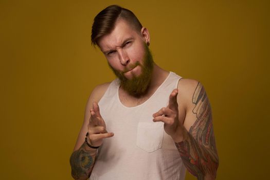 Cheerful bearded man in a white T-shirt with hooligan tattoos on his arms. High quality photo