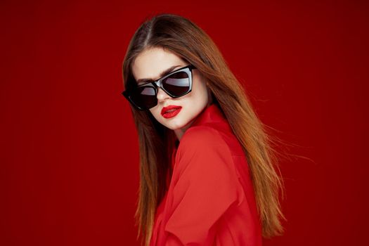 beautiful woman wearing sunglasses red shirt makeup isolated background. High quality photo