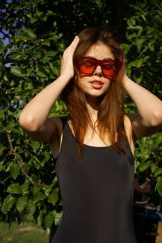 woman in black swimsuit sunglasses nature summer posing. High quality photo