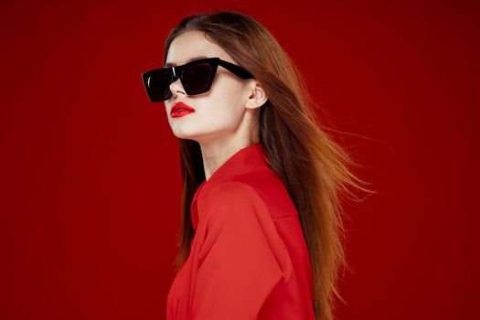 beautiful woman wearing sunglasses red shirt makeup isolated background. High quality photo