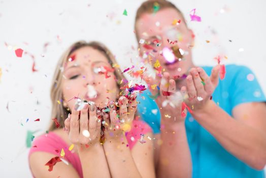 happy young romantic  couple in love  celebrating and blowing confetti decorations at new year and charismas  party