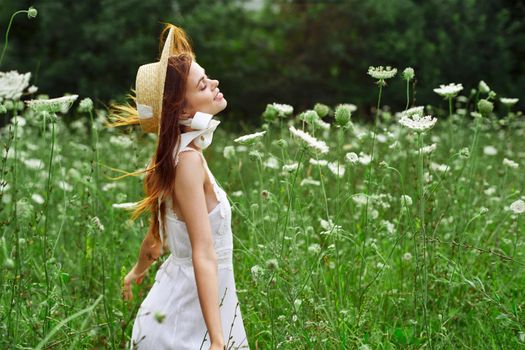 Woman in white dress and hat in a field with flowers lifestyle. High quality photo