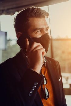 corporate businessman wearing a protective medical face mask at modern open space office concept of new normal in business