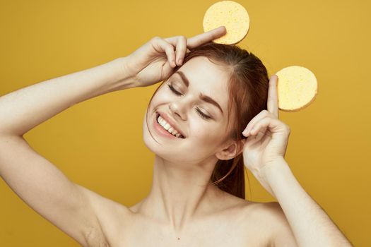 pretty woman with sponges in her hands bare shoulders clean skin hygiene. High quality photo