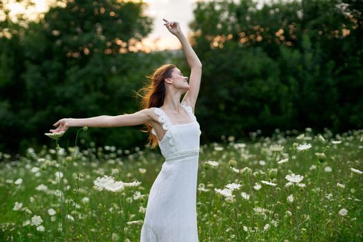 Woman in white dress in a field flowers sun nature freedom. High quality photo
