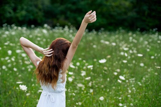 Woman in white dress in a field of flowers walk freedom. High quality photo