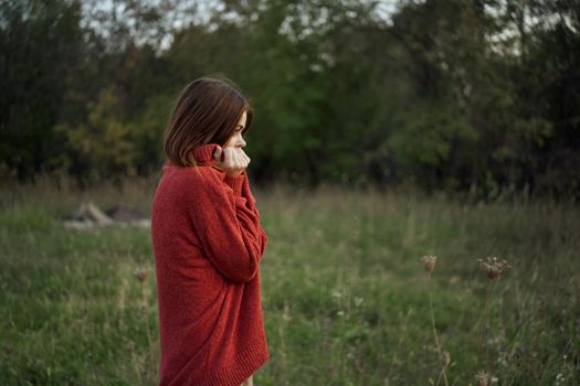 woman outdoors in a red sweater cool nature. High quality photo