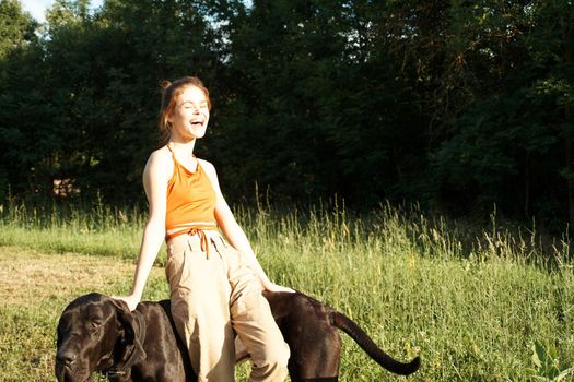 woman in the field in summer playing with a dog friendship. High quality photo