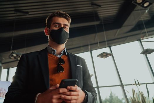 corporate businessman wearing a protective medical face mask at modern open space office concept of new normal in business