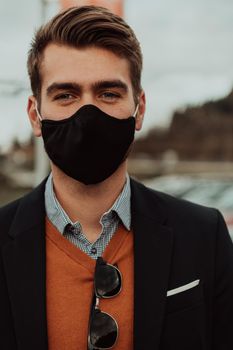 Young casual look businessman wearing a medical mask in the street urban enviroment