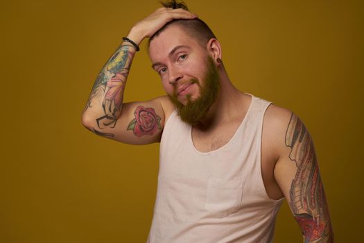 macho man in white t-shirt tattoos on his arms posing isolated background. High quality photo