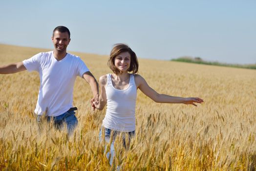 happy young couple in love have romance and fun at wheat field in summer