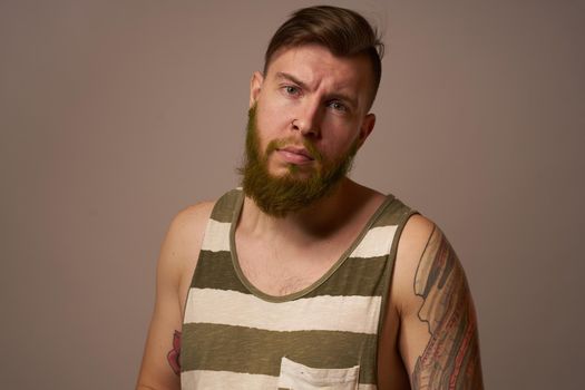 bearded man in striped t-shirt glasses tattoo on his arms fashion. High quality photo
