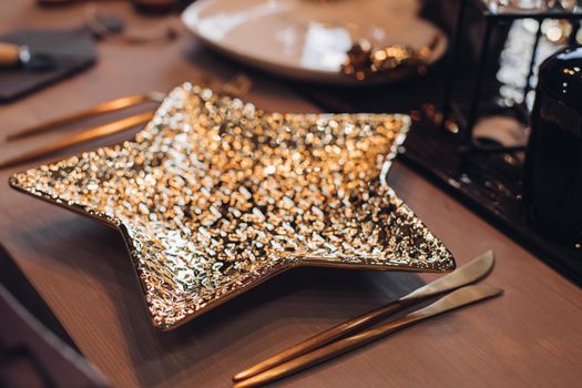 Golden star-shaped plate on New Year table. New Year eve concept