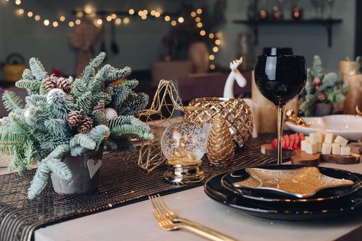 Photo of Christmas table decoration with festive dinnerware with candles. New Year eve concept