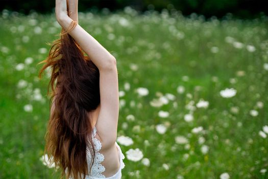 Woman in white dress in a field of flowers walk freedom. High quality photo