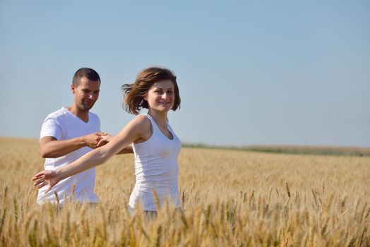 happy young couple in love have romance and fun at wheat field in summer