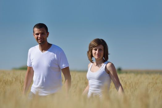 happy young couple in love have romance and fun at wheat field in summer