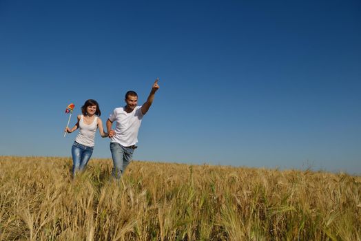 happy young couple in love have romance and fun at wheat field in summer