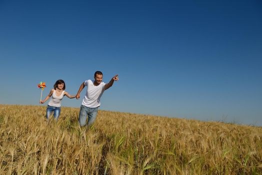 happy young couple in love have romance and fun at wheat field in summer