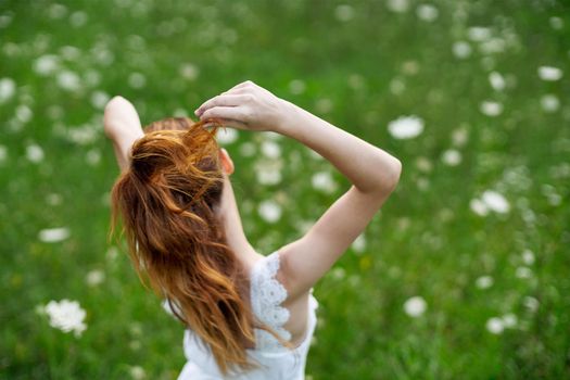 Woman in white dress in a field of flowers walk freedom. High quality photo