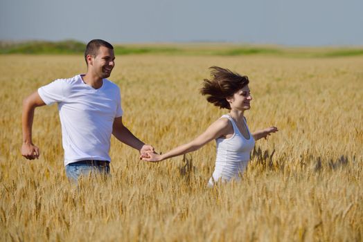 happy young couple in love have romance and fun at wheat field in summer