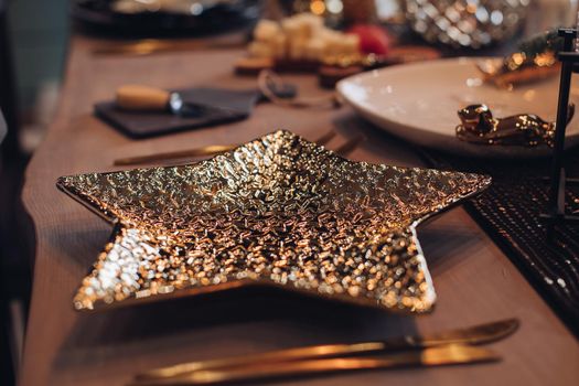 Golden star-shaped plate on New Year table. New Year eve concept