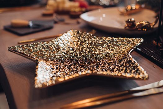 Golden star-shaped plate on New Year table. New Year eve concept