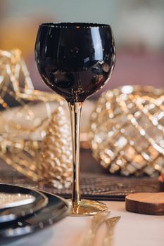 Close up of shiny wine glass on table decorated for Christmas. New Year eve concept