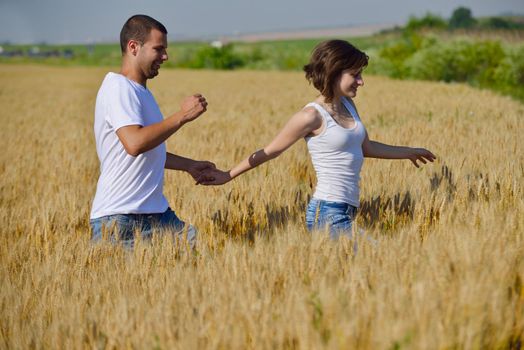 happy young couple in love have romance and fun at wheat field in summer