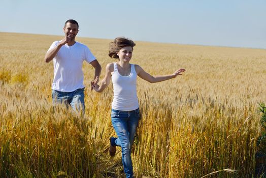 happy young couple in love have romance and fun at wheat field in summer