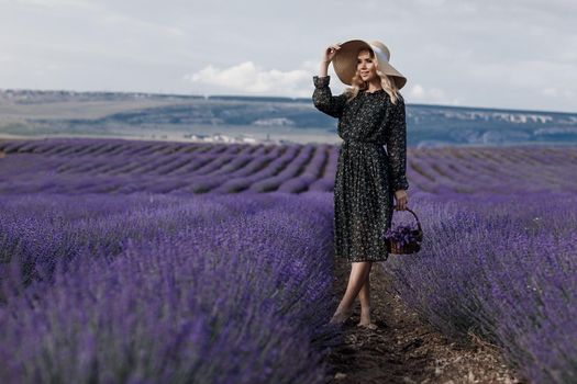 Fashion portrait of a pretty young woman in lavender field. High quality photo