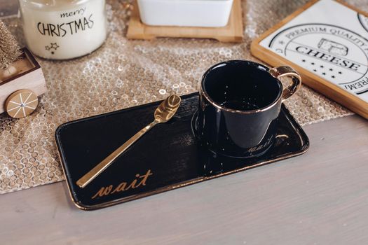 Black coffee mug on table decorated with New Year decor. New Year eve concept