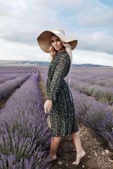 Fashion portrait of a pretty young woman in lavender field. High quality photo