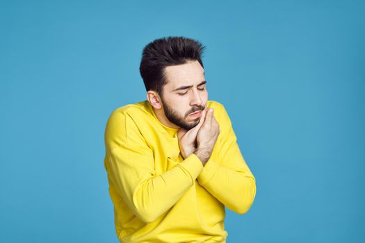 man in yellow sweater health problems emotions blue background. High quality photo