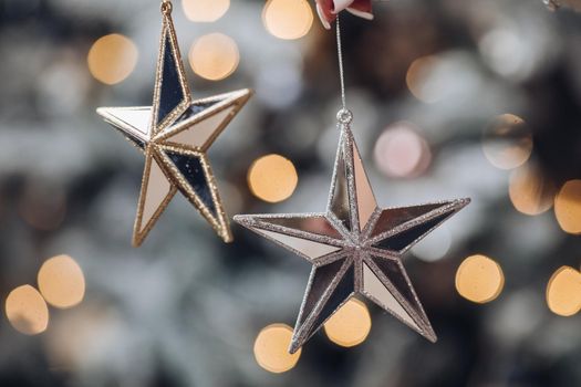 Close up of woman with toy glass decorative star in hands. New Year eve concept