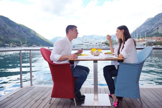 happy young couple having lanch at beautiful restaurant on by the sea on  beach