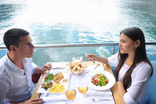 happy young couple having lanch at beautiful restaurant on the beach