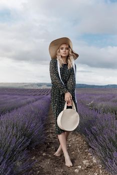 Fashion portrait of a pretty young woman in lavender field. High quality photo