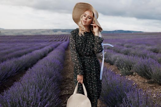 Fashion portrait of a pretty young woman in lavender field. High quality photo