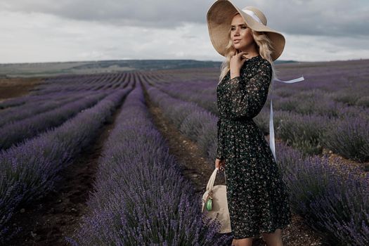 Fashion portrait of a pretty young woman in lavender field. High quality photo