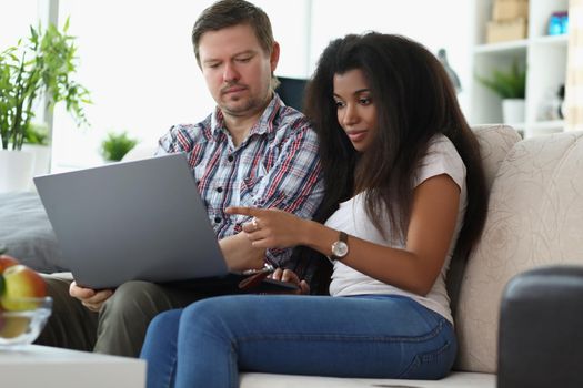 Portrait of middle aged man and latino american woman choosing something online. Couple want to buy furniture via online store. Online shopping concept