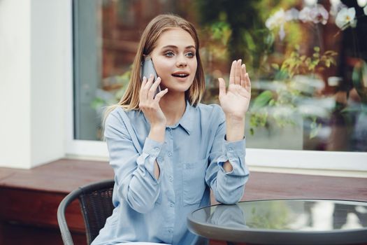 Business woman in a cafe in the summer outdoors on vacation. High quality photo