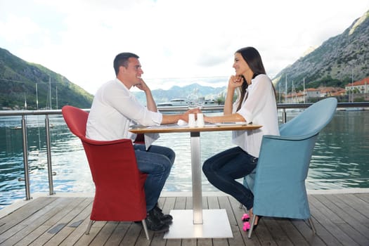 happy young couple having lanch at beautiful restaurant on the beach