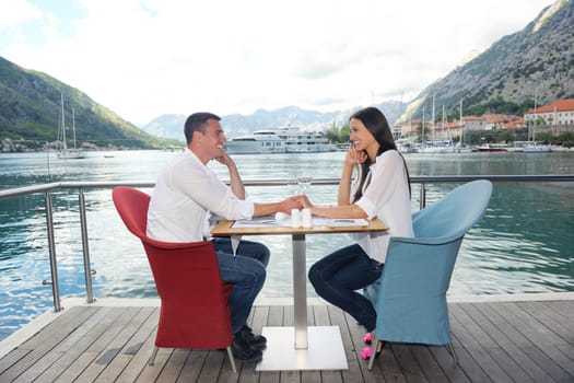 happy young couple having lanch at beautiful restaurant on by the sea on  beach