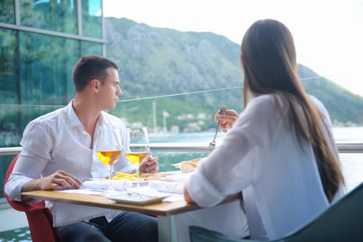 happy young couple having lanch at beautiful restaurant on by the sea on  beach