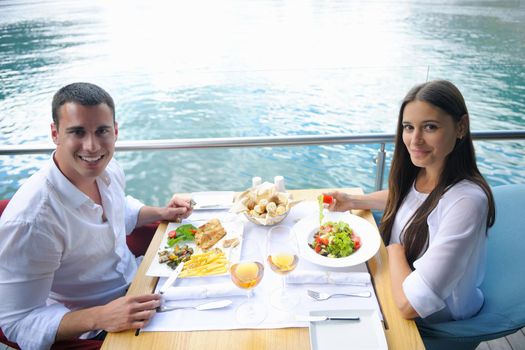 happy young couple having lanch at beautiful restaurant on by the sea on  beach